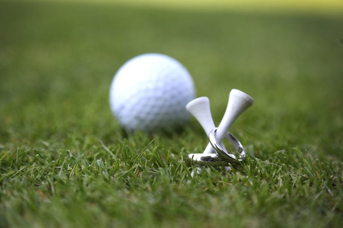 Wedding rings on golf tees photo with golfball in the background
