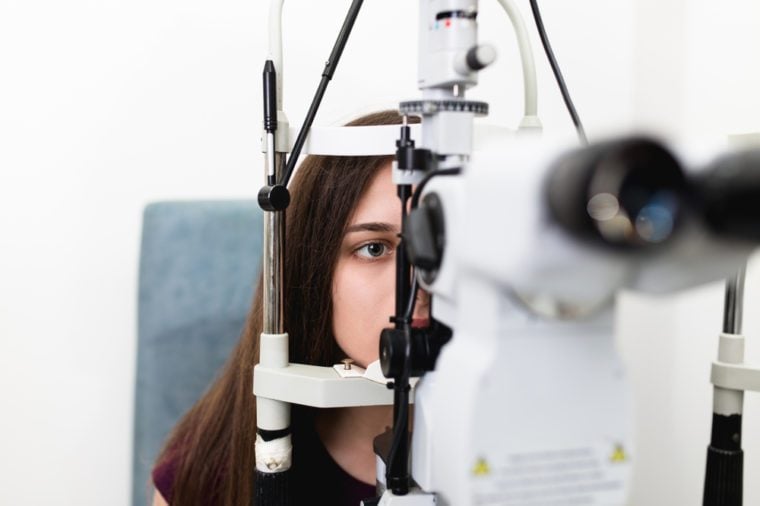 Female optometrist checking young and beautiful patient vision at eye clinic. Medical examination.