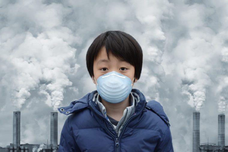 Asian boy wearing mouth mask against air pollution
