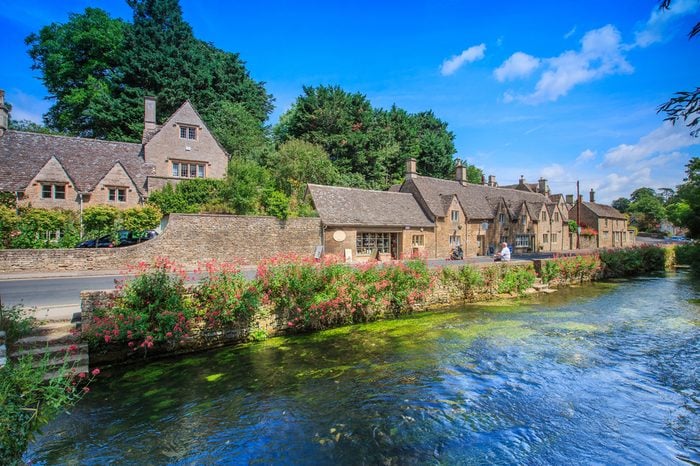BIBURY, ENGLAND, UK - JULY 9, 2014: Arlington Row traditional Cotswold stone cottages in Gloucestershire on JULY 9, 2014, England. Bibury it the most depicted village in the world.