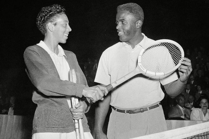Brooklyn Dodgers' second baseman, Jackie Robinson, gets tennis tips from tennis star Althea Gibson at the celebrity tennis tournament at the 7th Regiment Armory in New York, . The tournament was staged for the benefit of the American National Theater and Academy