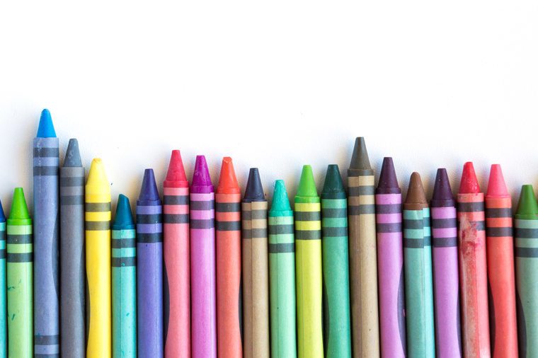Crayons and pastels lined up isolated on white background with copy space