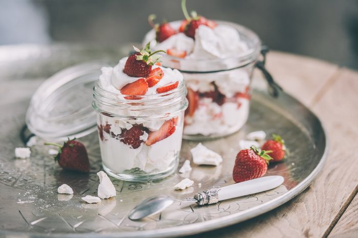 Classic british summer dessert called Eton Mess. Strawberries, crushed meringue and whipped cream in jar