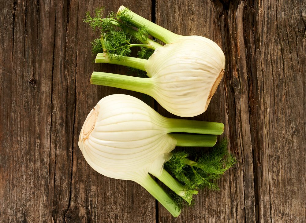 fresh fennel leaning on an old wooden table