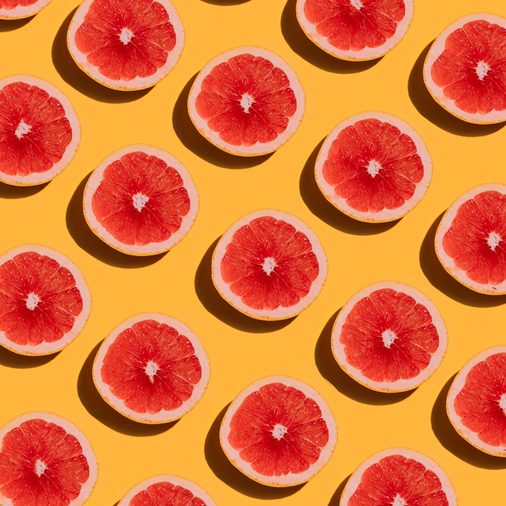 Grapefruit pattern on yellow background. Minimal flat lay concept.