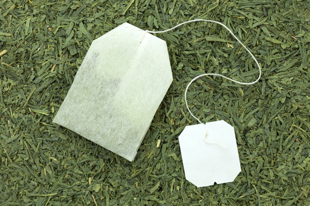 green tea bag on tea leaves