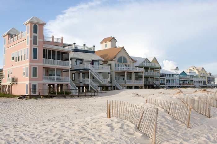 A row of luxury beach homes line the dunes along the Gulf Shores, Alabama coastline.
