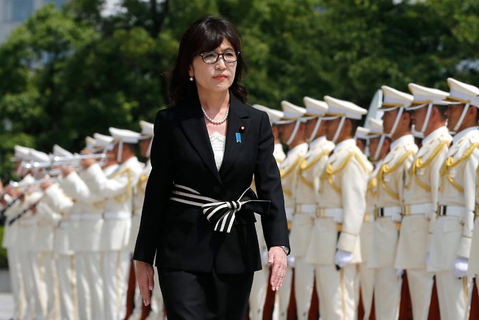 Japan's new Defense Minister Tomomi Inada inspects a honor guard on her first day at the Defense Ministry in Tokyo, . Inada, a woman with revisionist views of World War II history, has been named Japan's defense minister in a Cabinet reshuffle. Japanese Prime Minister Shinzo Abe changed more than half of the 19-member Cabinet on Wednesday in a bid to support his economic, security and other policy goals