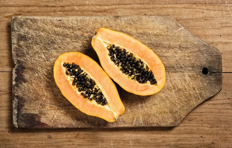 Papaya fruit sliced on a wooden cutting table