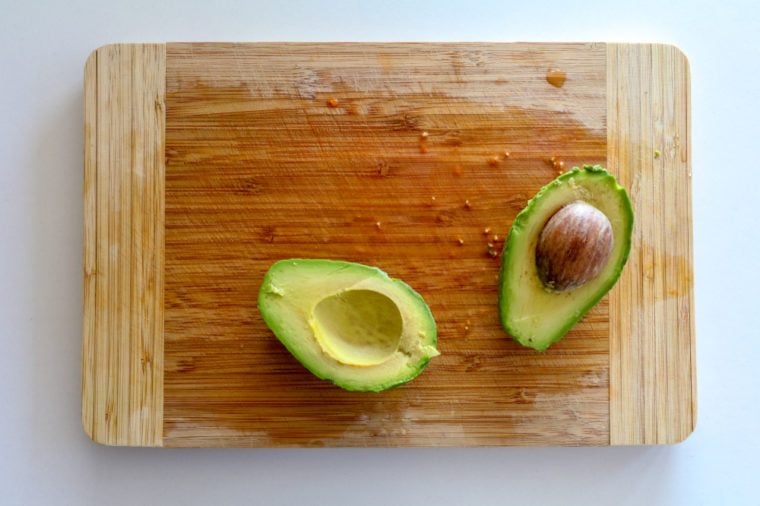 chopping board with sliced avocado from top view