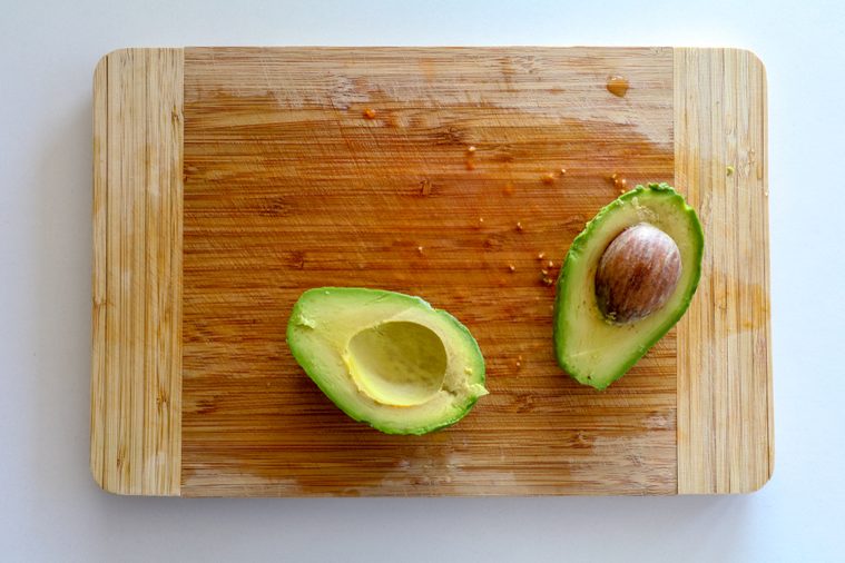 chopping board with sliced avocado from top view