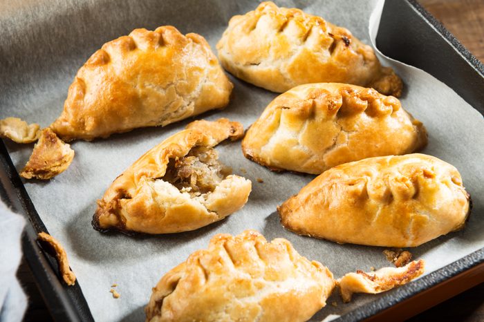 Hot pasties from butter enriched puff pastry filled with minced beef, potato, onions and swede in the iron pan