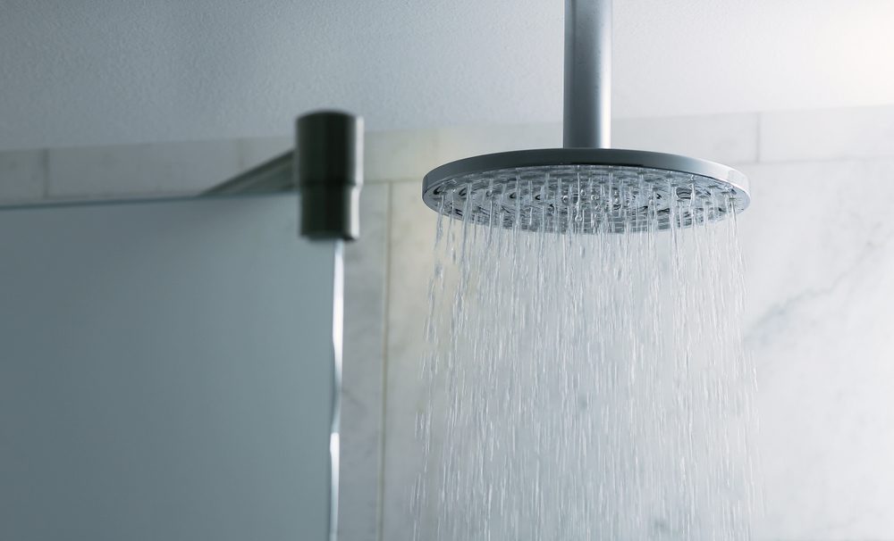 Shower turned on, ceiling shower head closeup