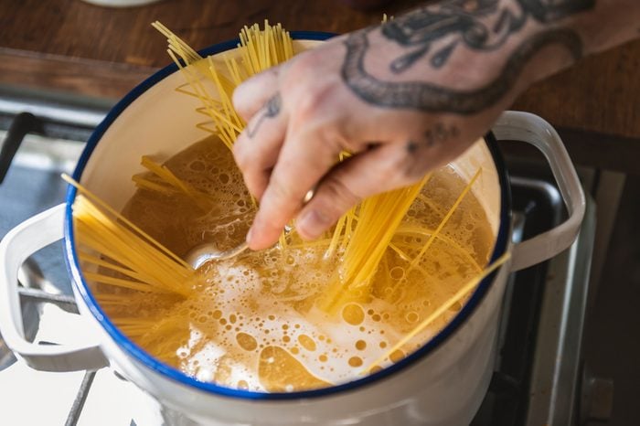 A chef boiling capellini pasta in the pot