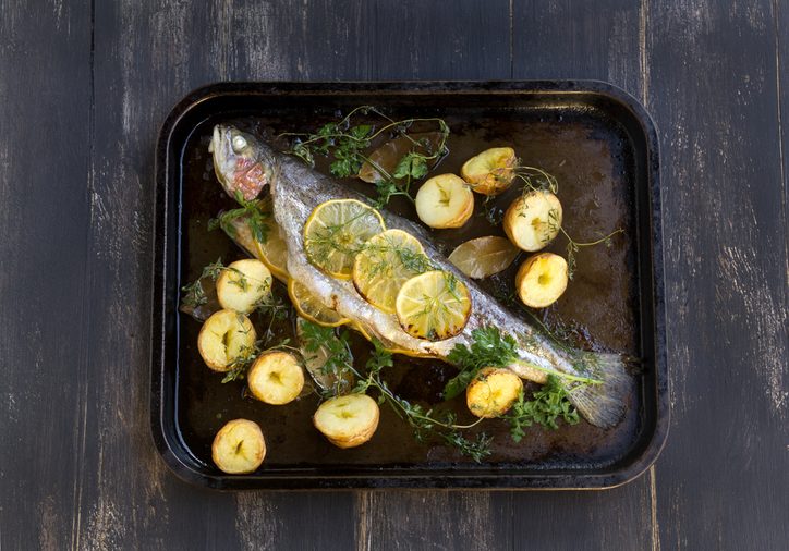 Delicious baked rainbow trout straight from the oven with potato, lemon and herbs.