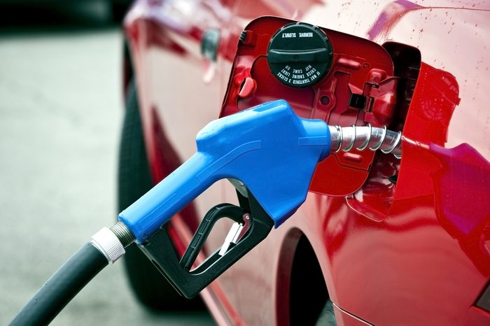 Blue Gasoline Nozzle Fueling Red Car/ Getting Gas/ Horizontal Shot