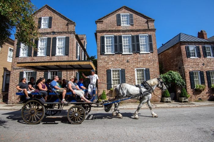 CHARLESTON, SC, USA -OCTOBER 13: Horse carriage with tourists enjoying facades of Societe Francaise on October 13, 2014 in Charleston, SC. Historic architecture attracts tourists to Charleston,SC..