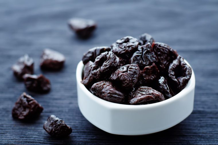 prunes in a bowl on a dark background. tinting. selective focus