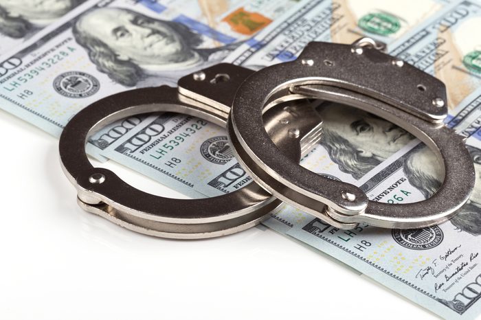 handcuffs on dollar banknotes background