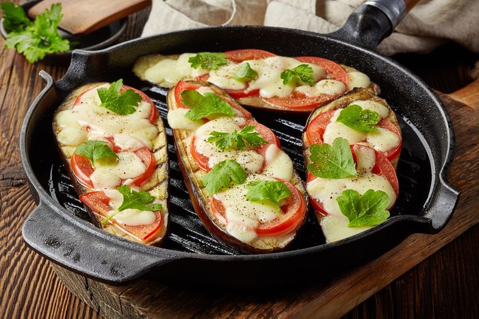 grilled eggplants with tomato and cheese on cooking pan