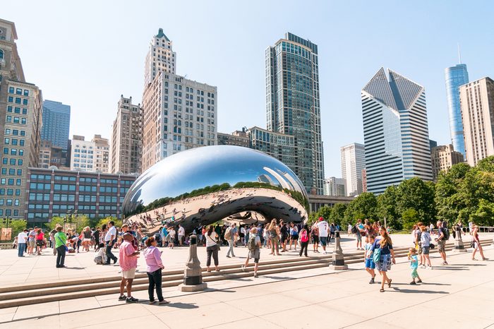 Chicago, Illinois, USA - August 15, 2014: Tourists visiting Cloud Gate, one of the most unique and interesting sculptures in decades graces the promenade at Chicago Millennium Park.