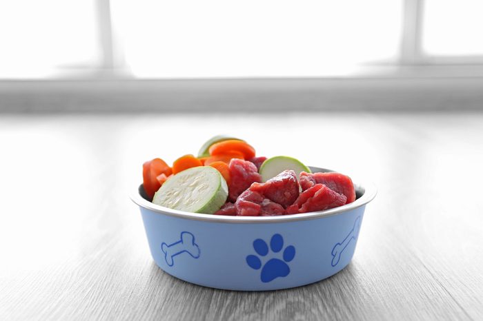 Organic dog food in a bowl on a wooden floor