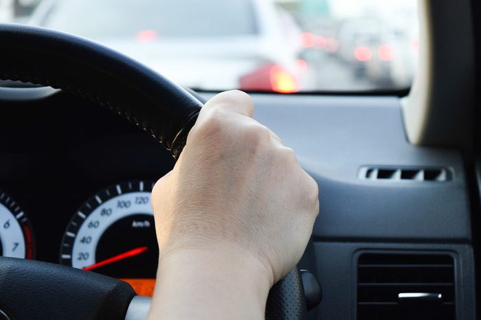 woman driving car, hand hold steering wheel in a traffic jam
