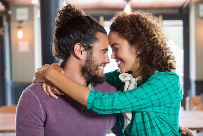 Cheerful young couple embracing in restaurant