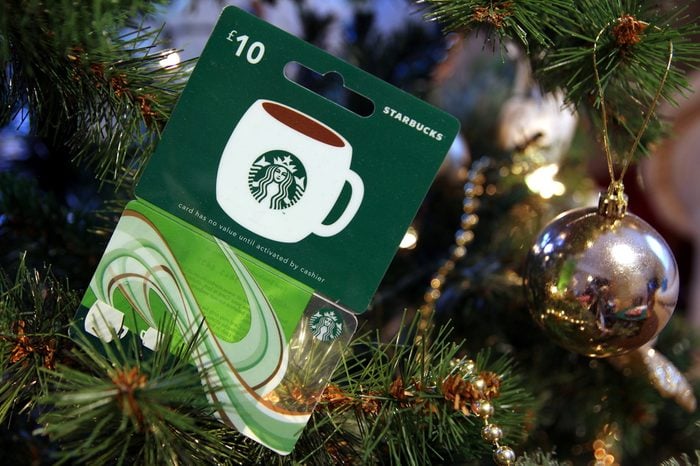 British Starbucks £10 gift card or voucher, nestled among the branches of a Christmas tree