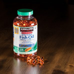 Kirkland Wild Alaskan Fish Oil capsules and bottle on wooden table