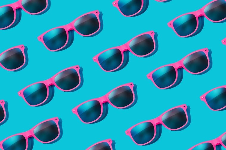 Pink sunglasses pattern on pastel blue background. Minimal summer concept. Flat lay.