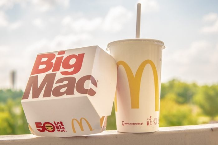 Warsaw, Poland, July 22, 2018 McDonald's Big Mac with two 100% pure beef patties and sauce sandwiched between sesame seed bun, with refreshing Coca-Cola Coke, big yellow McDonald's M sign, logo on cup