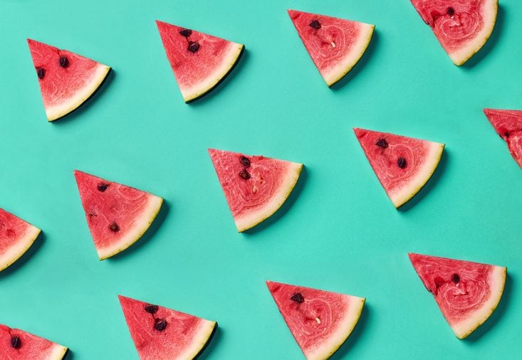 Colorful fruit pattern of fresh watermelon slices on blue background. From top view