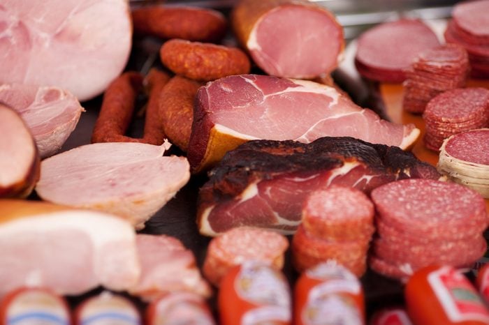 Closeup of a variety of cooked meats, salamis and sausages at a delicatessen