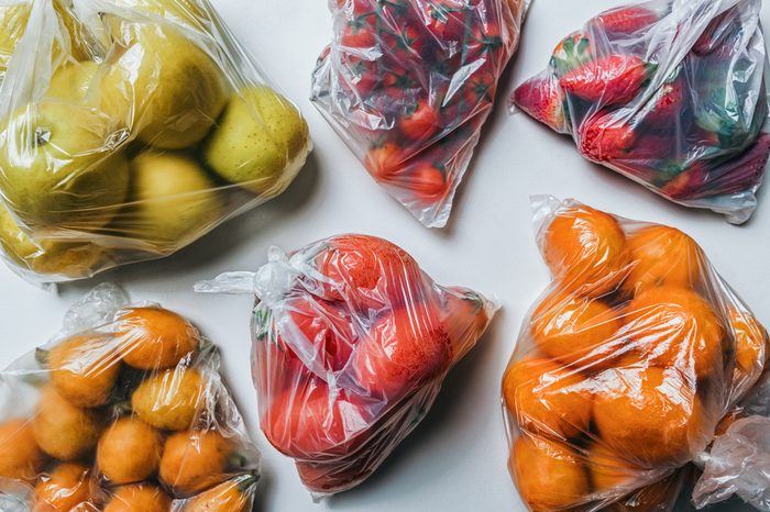 Closeup of plastic bags full of fruits and vegetables. Climate change and less plastic concept. Flat lay