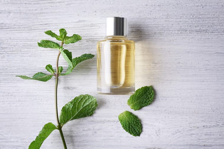 Essential oil with mint on wooden table