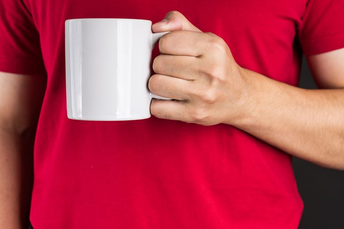Man in red t-shirt holding Coffee mug with two hand