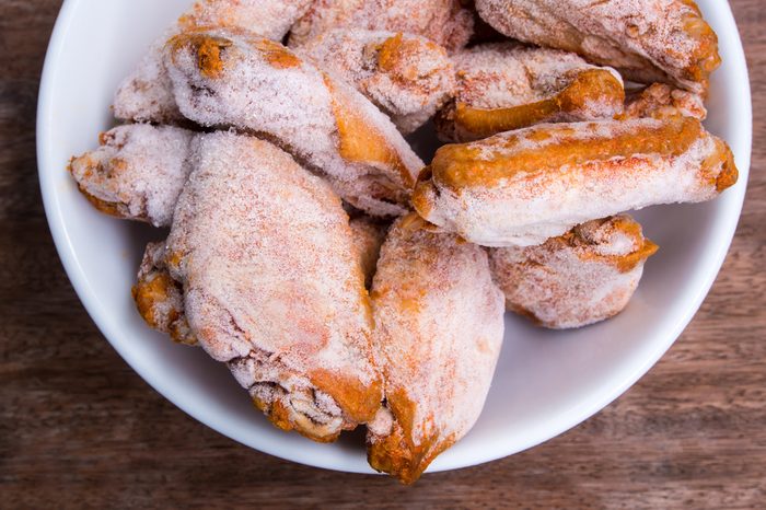 Some pieces of frozen fried chicken wings prepare for cook