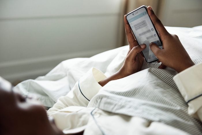 A woman using a phone in bed