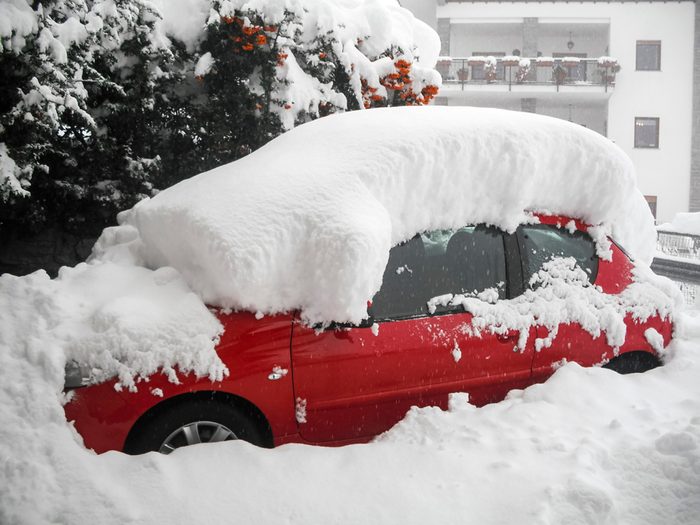 A red car covered by snow at Valpelline Village, Aosta Valley Province, Italy