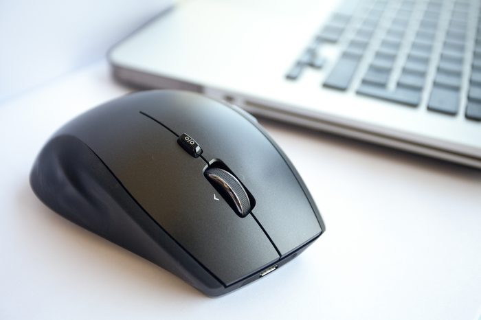 Wireless mouse is located near the laptop. White background, close up