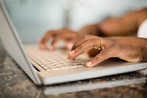 Close up of masculine hands typing on laptop keyboard