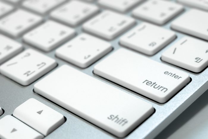 Close up keyboard of a computer on focus at enter button (English - Thai language)