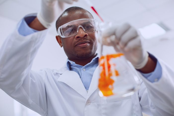 Testing human blood. Skilled afro-american biologist conducting a test and wearing glasses