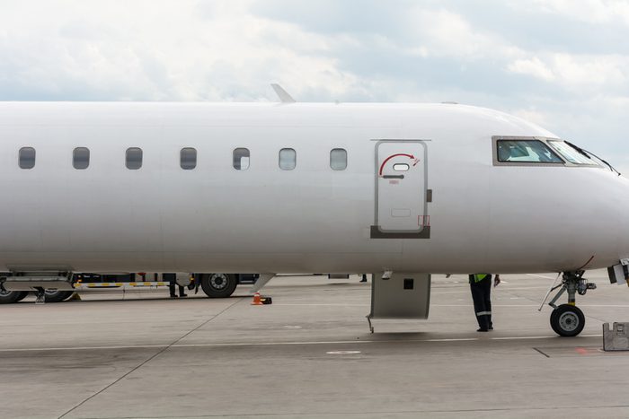 a typical white passenger jet plane/ regional airplane is waiting for boarding passengers, staying in the airport, side view