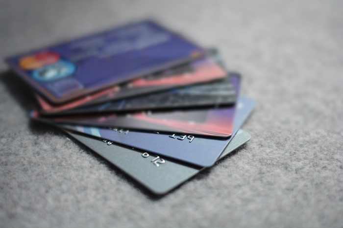 Colorful stack of credit cards and shopping gift cards on gray carpet back ground. Extremely shallow dof.