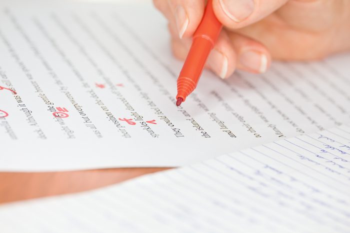 Proofreader with red pen checks a transcribed page