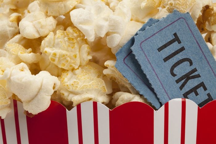 close up of two tickets stubs in a box of popcorn. Concept of movie time.