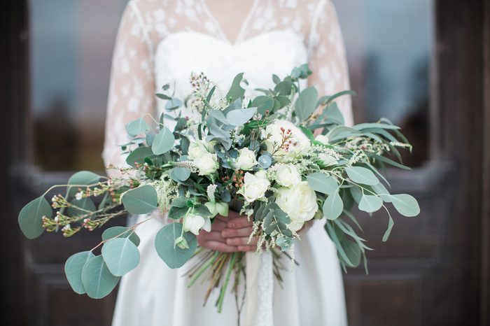 Handed wedding bouquet with roses and eucalyptus greenery. 