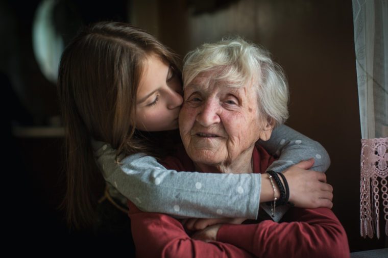 A little girl hugs her grandmother.